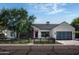 Modern farmhouse exterior with a white facade, dark wood accents, and a landscaped front yard at 3837 E Heatherbrae Dr, Phoenix, AZ 85018