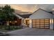 Modern farmhouse exterior with a white facade, dark wood accents, and a landscaped front yard at 3837 E Heatherbrae Dr, Phoenix, AZ 85018