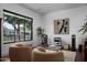 Bright sitting room with large windows, comfortable seating, and modern art at 3837 E Heatherbrae Dr, Phoenix, AZ 85018