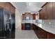 Kitchen features dark wood cabinets, granite counters, and black appliances at 415 E Glenhaven Dr, Phoenix, AZ 85048