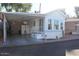 Front view of the manufactured home with carport and storage shed at 4220 E Main St # F-45, Mesa, AZ 85205