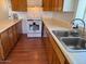 Kitchen with wood cabinets, white appliances, and double sink at 469 W Newmont St, Superior, AZ 85173