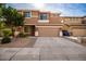 Two-story house with tan exterior, two-car garage, and landscaping at 4723 W Gelding Dr, Glendale, AZ 85306