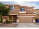 Two-story house with tan exterior, two-car garage, and landscaping at 4723 W Gelding Dr, Glendale, AZ 85306