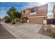 Two-story house with tan exterior, two-car garage, and landscaping at 4723 W Gelding Dr, Glendale, AZ 85306