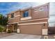 Two-story house with tan exterior, two-car garage, and landscaping at 4723 W Gelding Dr, Glendale, AZ 85306