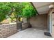 Private patio with lush green trees and a brick wall at 4800 N 68Th St # 264, Scottsdale, AZ 85251