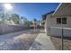 Landscaped backyard with gravel, chain link fence, and covered patio at 6323 N 65Th Dr, Glendale, AZ 85301