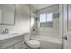 Clean bathroom, featuring a bathtub, gray vanity, and marble tile at 6323 N 65Th Dr, Glendale, AZ 85301