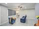 Bright living room featuring a comfortable blue reclining sofa and tile flooring at 6323 N 65Th Dr, Glendale, AZ 85301