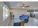 Bright living room featuring a comfortable blue reclining sofa and tile flooring at 6323 N 65Th Dr, Glendale, AZ 85301