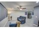 Bright living room featuring a comfortable blue reclining sofa and tile flooring at 6323 N 65Th Dr, Glendale, AZ 85301