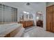 Elegant bathroom featuring a double vanity, soaking tub, and views into another room at 6502 N 81St Pl, Scottsdale, AZ 85250