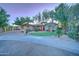 House exterior at dusk with palm trees and a landscaped lawn at 6502 N 81St Pl, Scottsdale, AZ 85250