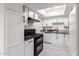 Modern kitchen with white cabinets, granite countertops, and black appliances at 6820 N 81St Ln, Glendale, AZ 85303