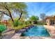 Inviting backyard oasis featuring a sparkling pool, water features, and lush landscaping at 7257 E Visao Dr, Scottsdale, AZ 85266