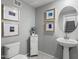 Clean and updated bathroom with pedestal sink and framed art at 730 E Zesta Ln # 101, Gilbert, AZ 85297