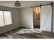 Bedroom with white barn door, window blinds, and wood-look floors at 805 W Raymond St, Coolidge, AZ 85128