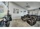 Comfortable home theater room with reclining leather seating, a ceiling fan, and a large screen television at 8149 W Daley Ln, Peoria, AZ 85383