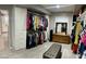 Organized walk-in closet with custom shelving, ample hanging space, bench, and an abundance of natural light at 8149 W Daley Ln, Peoria, AZ 85383