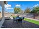 Cozy backyard with an outdoor dining area, artificial grass and desert landscaping at 13022 W Surrey Ave, El Mirage, AZ 85335