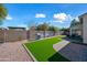 Beautiful backyard with artificial grass, stone perimeter, barbeque and desert landscaping at 13022 W Surrey Ave, El Mirage, AZ 85335