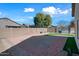Large backyard with gravel landscaping, green turf, brick patio, and privacy wall perfect for outdoor activities at 13022 W Surrey Ave, El Mirage, AZ 85335
