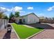 Spacious backyard featuring gravel landscaping, green turf area, brick patio, and grill, perfect for outdoor activities at 13022 W Surrey Ave, El Mirage, AZ 85335