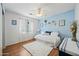 Bedroom features light blue accent wall, hardwood floors, and a ceiling fan at 13022 W Surrey Ave, El Mirage, AZ 85335