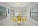 Dining area bathed in natural light with white tile flooring, complemented by a modern yellow table and chairs at 13022 W Surrey Ave, El Mirage, AZ 85335