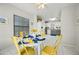 Dining area bathed in natural light with tile floors, complemented by a modern yellow table and chairs at 13022 W Surrey Ave, El Mirage, AZ 85335