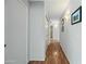 Hallway features hardwood floors, neutral paint, modern lighting, and access to the bathroom and bedroom at 13022 W Surrey Ave, El Mirage, AZ 85335