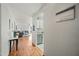 Bright hallway leading to the living room and kitchen, featuring stylish decor and hardwood floors at 13022 W Surrey Ave, El Mirage, AZ 85335