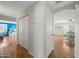 Hallway with hardwood floors leading to a bedroom and dinning area at 13022 W Surrey Ave, El Mirage, AZ 85335