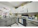 Charming kitchen with gray countertops, white cabinets, and black hardware that offers a functional cooking space at 13022 W Surrey Ave, El Mirage, AZ 85335