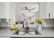 Bright and airy kitchen featuring stainless steel double sinks and views into the open-concept living areas at 13022 W Surrey Ave, El Mirage, AZ 85335