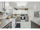 Well-lit kitchen with stainless steel appliances, white cabinetry, and sleek countertops, perfect for cooking and entertaining at 13022 W Surrey Ave, El Mirage, AZ 85335