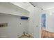 Laundry room features shelving, a utility sink, and washer/dryer hookups at 13022 W Surrey Ave, El Mirage, AZ 85335