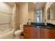 Bright bathroom featuring a vanity with a granite countertop, a shower and bath, and white tile walls at 13412 N 14Th Pl, Phoenix, AZ 85022