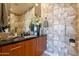Stylish bathroom featuring wooden vanity, modern fixtures, decorative wallpaper, and ample lighting at 13412 N 14Th Pl, Phoenix, AZ 85022
