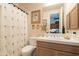 Cozy bathroom with a shower, decorated shower curtain, toilet, vanity and is connected to the home's rooms at 13412 N 14Th Pl, Phoenix, AZ 85022