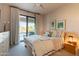 This cozy bedroom features a ceiling fan, exterior access, tasteful furniture and bright natural lighting at 13412 N 14Th Pl, Phoenix, AZ 85022