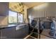 Modern laundry room with stainless steel sink, front loading washer and dryer, and granite countertops at 13412 N 14Th Pl, Phoenix, AZ 85022