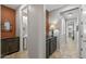 A bright hallway with dark brown cabinets and access to a bathroom at 13648 W Desert Glen Dr, Sun City West, AZ 85375