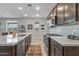 Modern kitchen with island, stainless steel appliances, and dark cabinets at 13648 W Desert Glen Dr, Sun City West, AZ 85375