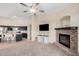 Living room featuring a fireplace, kitchen island, and ceiling fan at 14836 W Desert Hills Dr, Surprise, AZ 85379