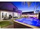 This backyard features a covered patio, a pool, a hot tub and manicured artificial lawn at 17706 W Villa Chula Ln, Surprise, AZ 85387