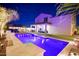 The spacious backyard has a covered patio, manicured lawn, and a sparkling pool at 17706 W Villa Chula Ln, Surprise, AZ 85387