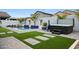 Backyard with a sparkling pool, spa, artificial turf, and mature palm trees at 17706 W Villa Chula Ln, Surprise, AZ 85387