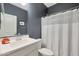 A well-lit bathroom with a clean white vanity, neutral walls, and a shower with a white curtain, creating a soothing space at 17706 W Villa Chula Ln, Surprise, AZ 85387